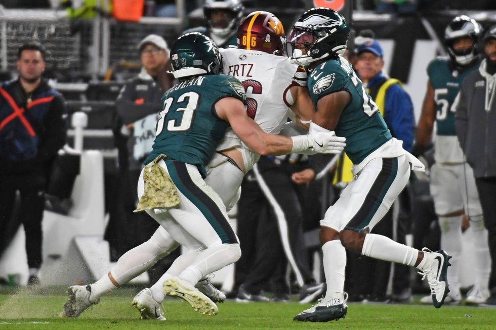 Philadelphia Eagles cornerback Cooper DeJean (33) and cornerback Quinyon Mitchell (27) tackle Washington Commanders offensive tackle Brandon Coleman (74) at Lincoln Financial Field.