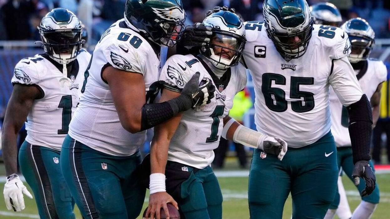 Philadelphia Eagles' Jalen Hurts (1) celebrates with Lane Johnson (65) and Jordan Mailata (68) after running for a two-point conversion during the second half of an NFL football game against the Chicago Bears, Sunday, Dec. 18, 2022, in Chicago.