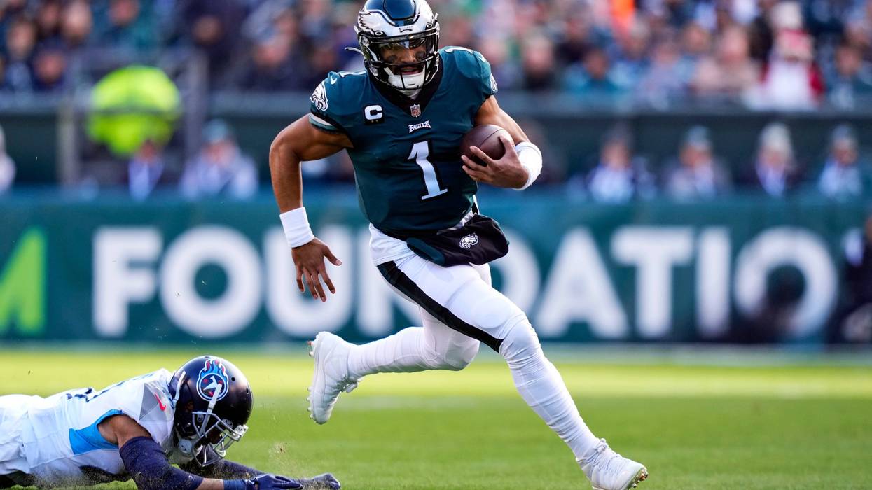 Philadelphia Eagles' Jalen Hurts runs past Tennessee Titans' Andrew Adams during the first half of an NFL football game, Sunday, Dec. 4, 2022, in Philadelphia.