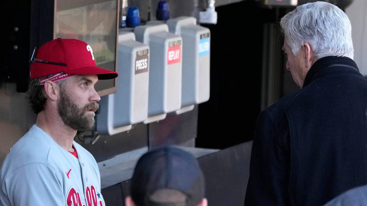 Philadelphia Phillies' Bryce Harper, left, listens to club President David Dombrowski, after Harper's workout before game one of a baseball double header against the Chicago White Sox, April 18, 2023, in Chicago.