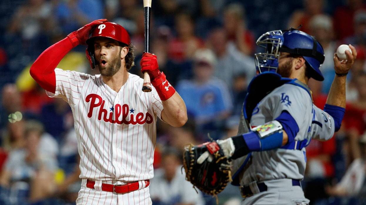 Philadelphia Phillies' Bryce Harper, left, reacts after striking out against Los Angeles Dodgers relief pitcher Julio Urias during the fourth inning of a baseball game Wednesday, July 17, 2019, in Philadelphia.