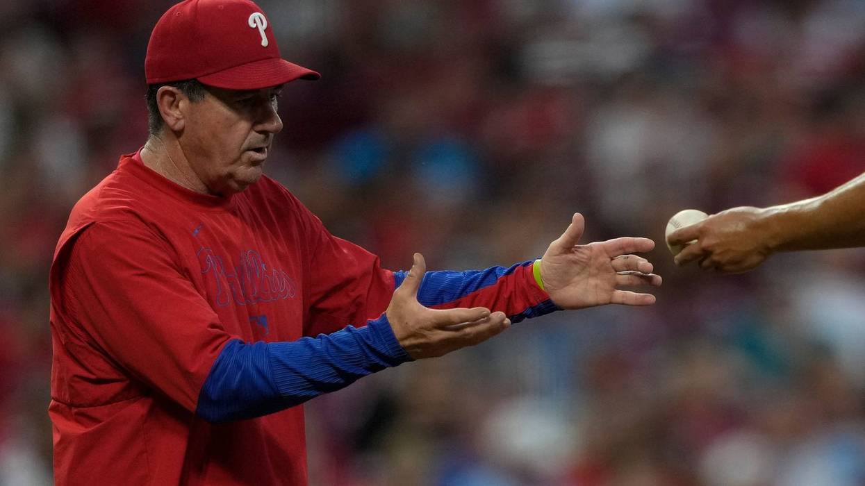 Philadelphia Phillies manager Rob Thomson, left, takes the ball from pitcher Ranger Suárez during a pitching change in the sixth inning of a baseball game against the Cincinnati Reds on Aug. 12, 2025, in Cincinnati.