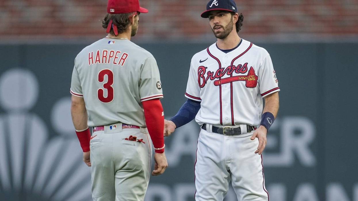 Philadelphia Phillies right fielder Bryce Harper talks to Atlanta Braves shortstop Dansby Swanson on the field before a game at Truist Park.