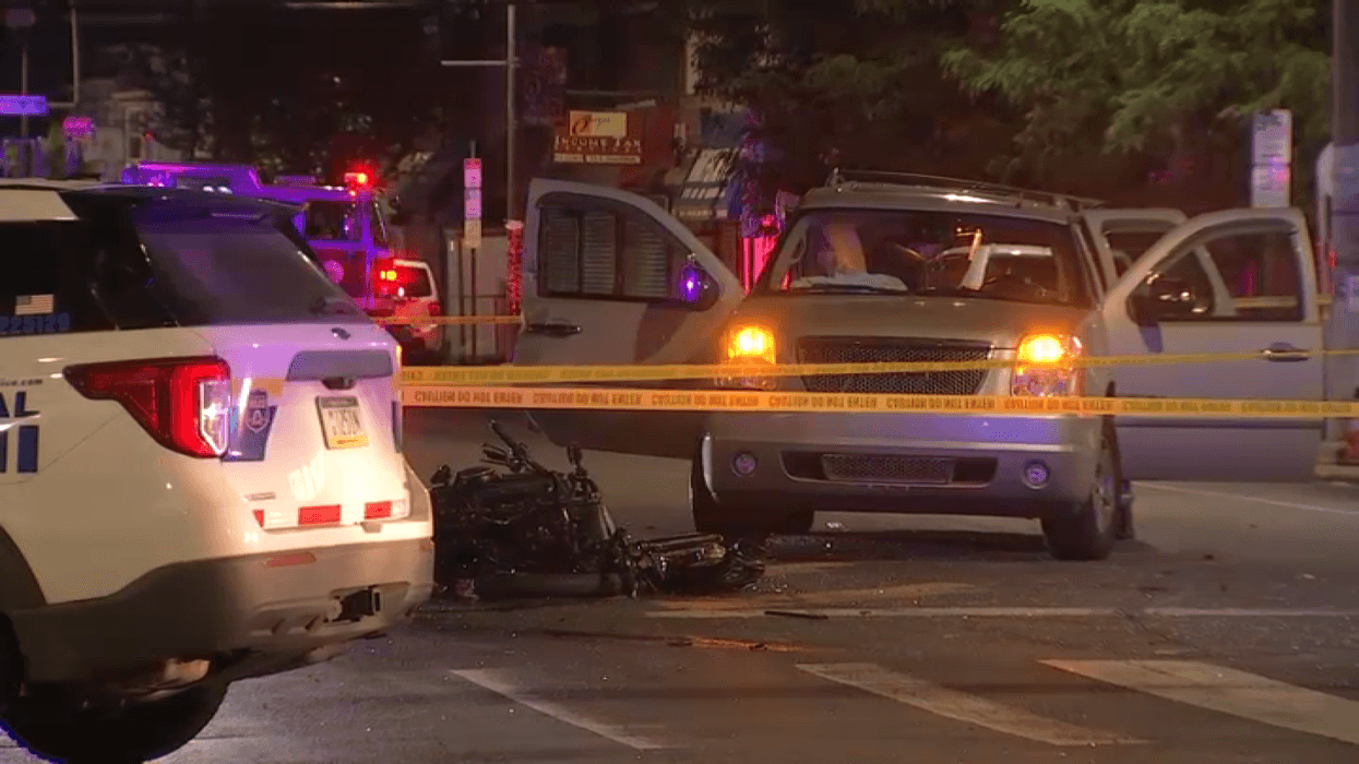 Philadelphia police at an accident scene, with a wrecked motorcycle and a GMC SUV.