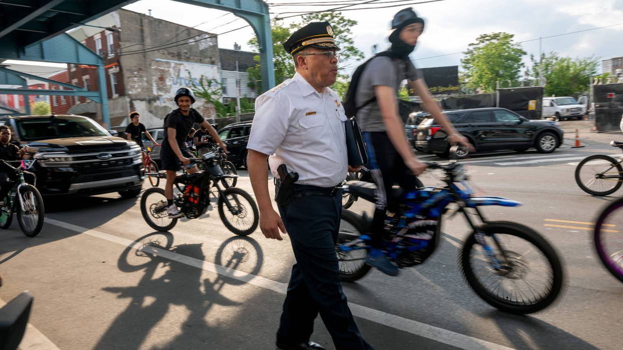 Philadelphia Police Commissioner Kevin Bethel walks through Kensington, flanked by bicyclists.