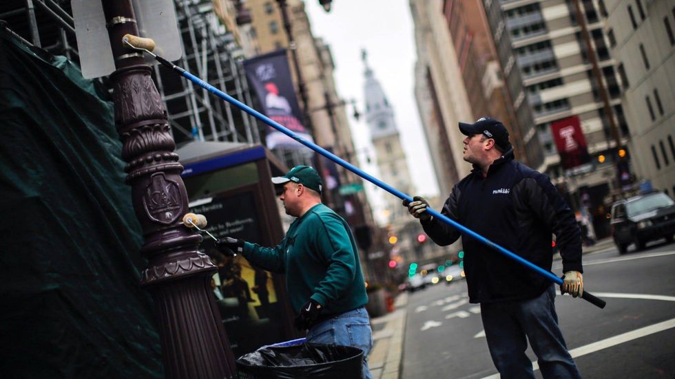 Philadelphia Police officers grease traffic light poles as a security measure on Feb. 4, 2018, in advance of the Eagles