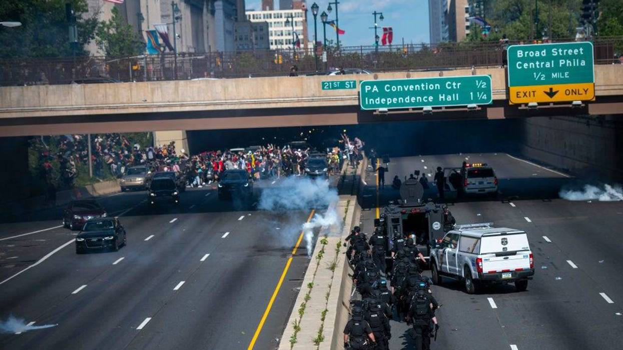Philadelphia police officers throw and shoot tear gas into a group of protesters after a march through Center City on June 1, 2020.