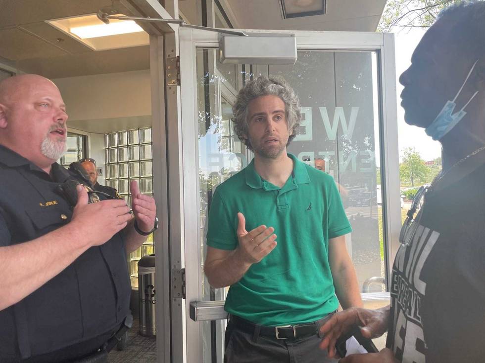 Phillip Holmes (R) and David Boehnke (M) from Twin Cities Incarcerated Workers Organizing Committee speaking with a member of the Minnesota Department of Corrections.