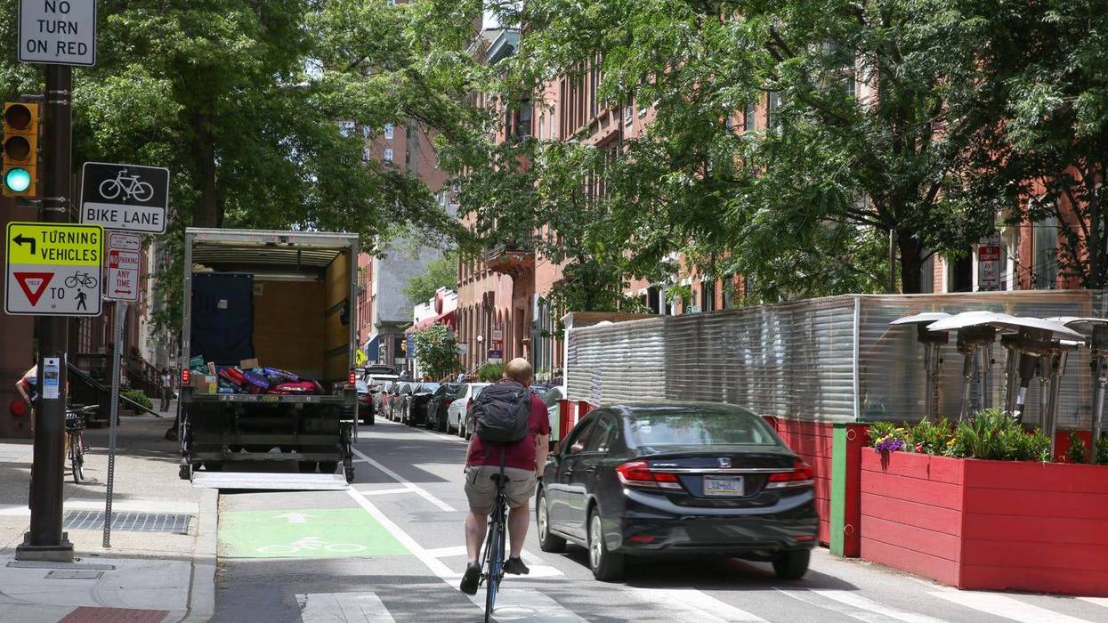 Philly biker riding around the bike lane to avoid a truck parked in the middle of it.