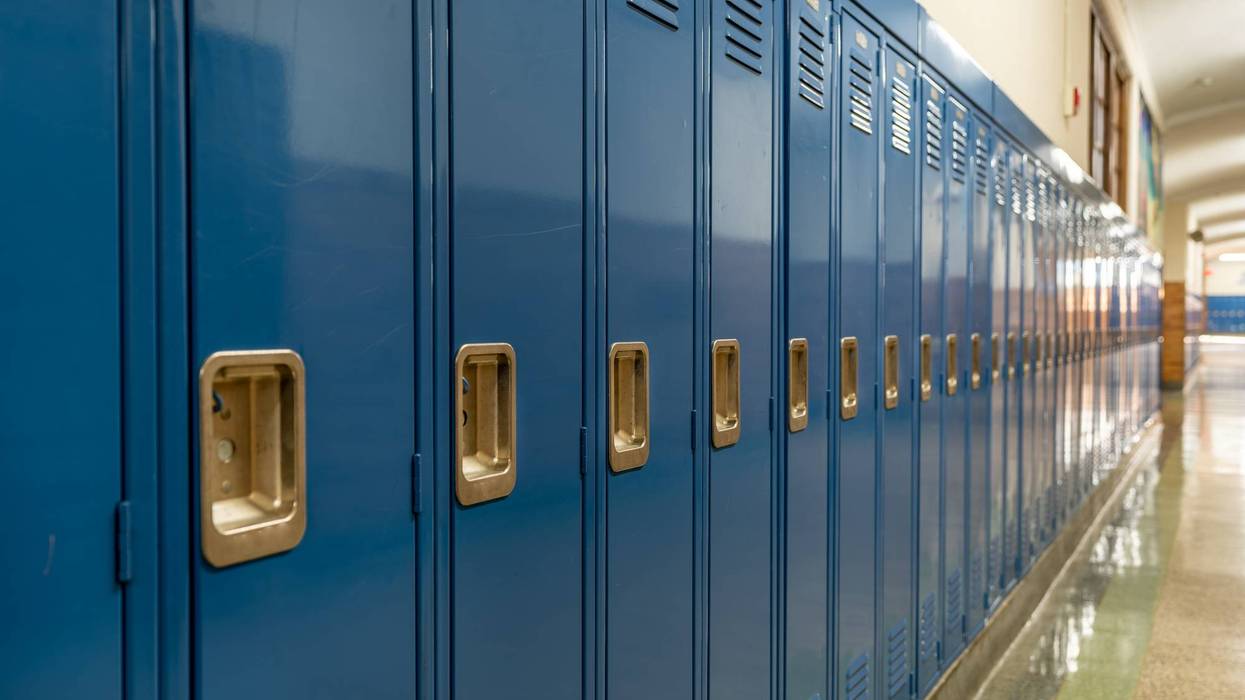 Photo of a blue metal lockers along a nondescript hallway in a typical US High School. No identifiable information included and nobody in the hall.