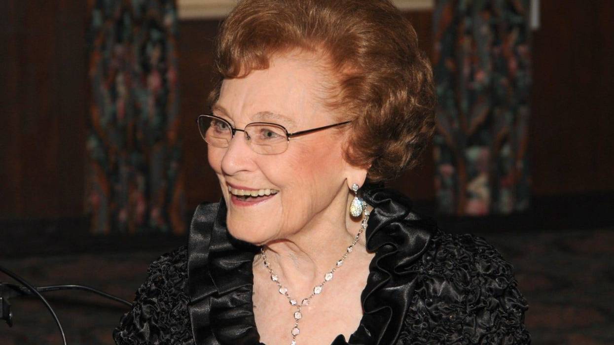 Photo of Dorothy Hecht Zehnder smiling, wearing a black top, dangling earrings and necklace