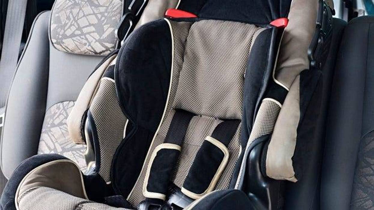 Photograph of a child safety seat in backseat of car.