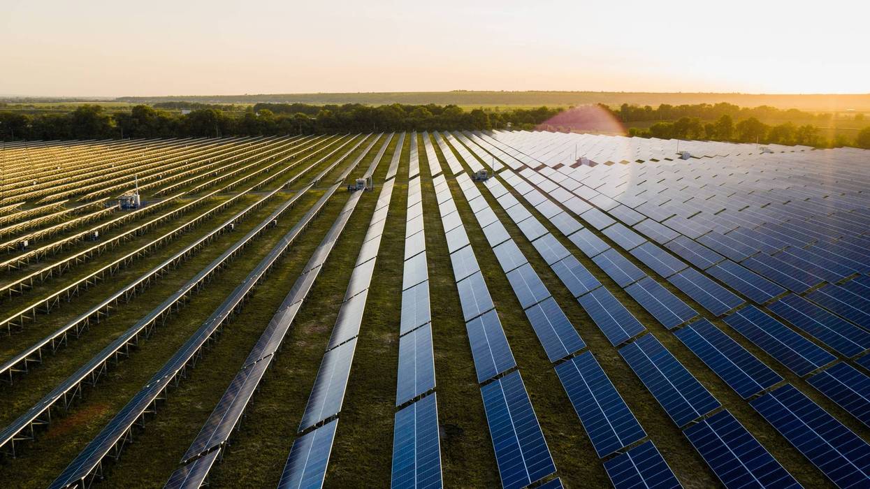 Photovoltaic modules reflect sunset light and clouds