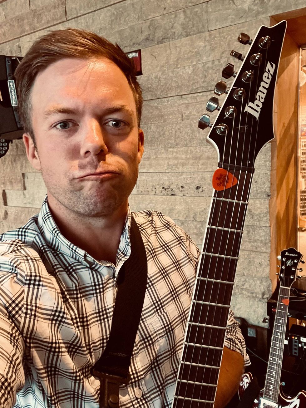 Pike making a silly face while holding his guitar during sound check.