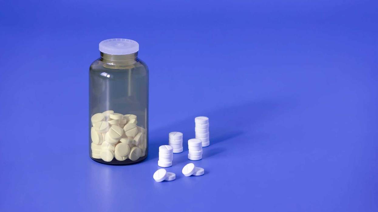 Pills in a bottle and on the counter.