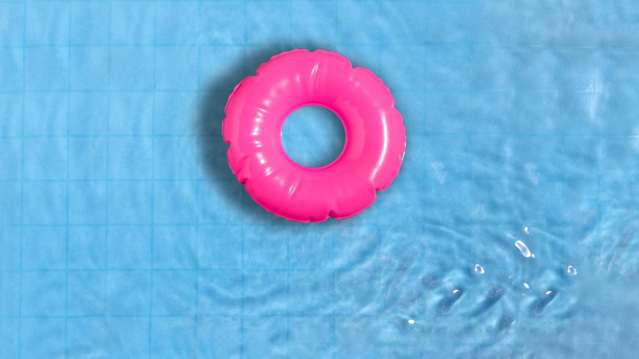 Pink ring floating in refreshing blue swimming pool.