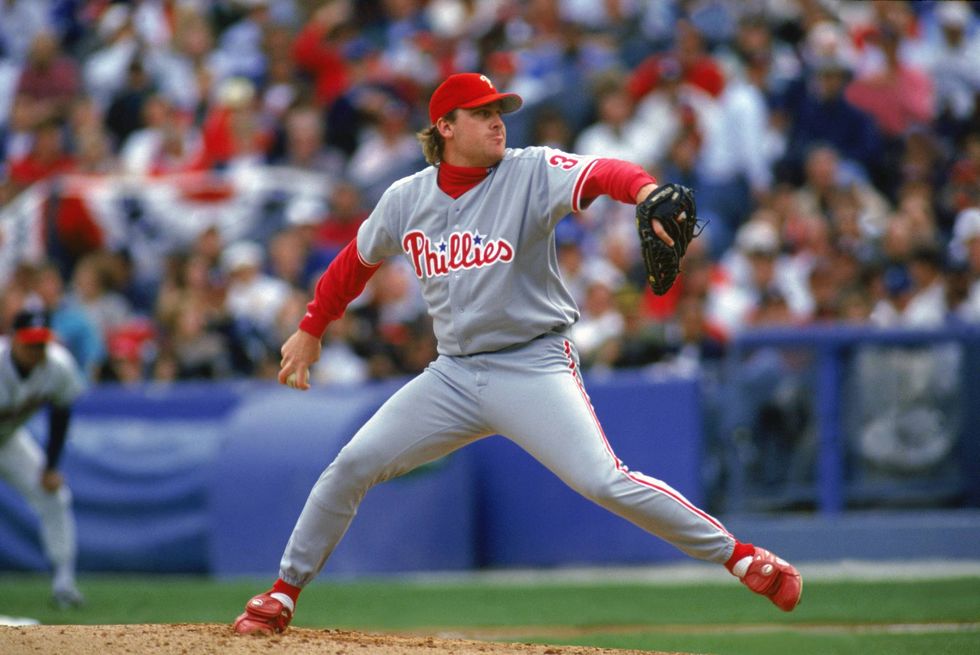 Pitcher Curt Schilling of the Philadelphia Phillies steps into a pitch during the National League Championship Series Game 5 on October 11, 1993 against the Atlanta Braves at Fulton County Stadium in Atlanta, Georgia.