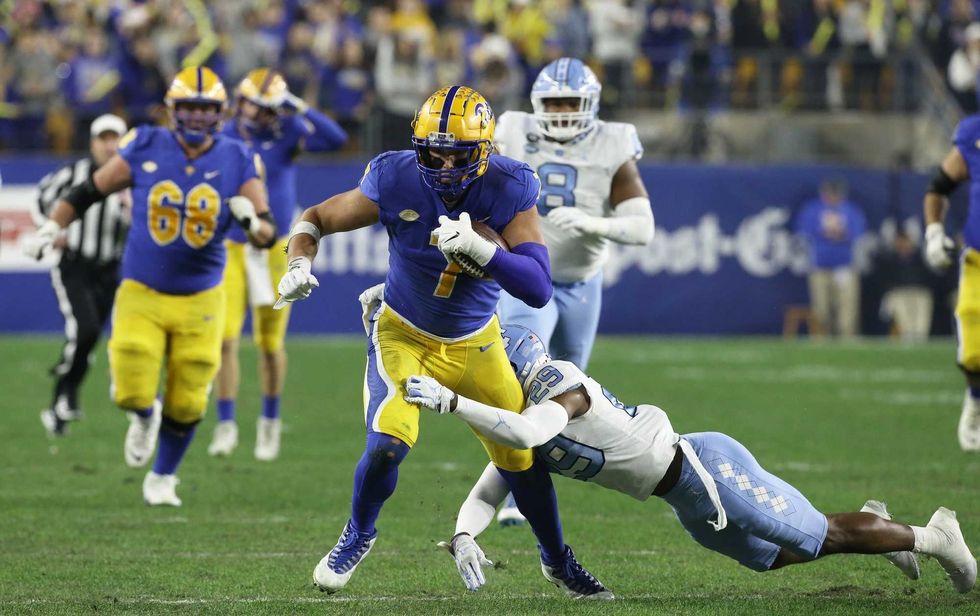 Pittsburgh Panthers tight end Lucas Krull (7) runs after a catch as North Carolina Tar Heels defensive back Storm Duck (29) defends during the first quarter at Heinz Field.