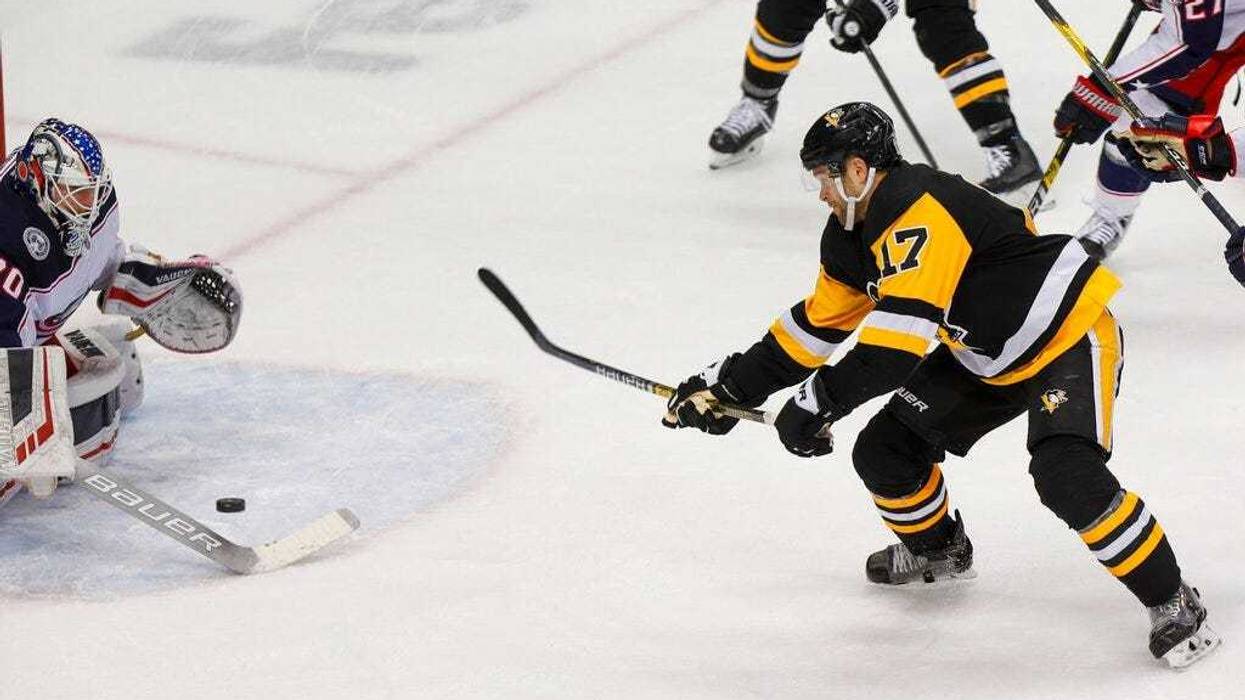 Pittsburgh Penguins' Bryan Rust (17) shoots and scores the game winning goal on Columbus Blue Jackets goaltender Joonas Korpisalo, left, during the overtime period of an NHL hockey game, Thursday, Dec. 12, 2019, in Pittsburgh. Pittsburgh Penguins won 1-0.
