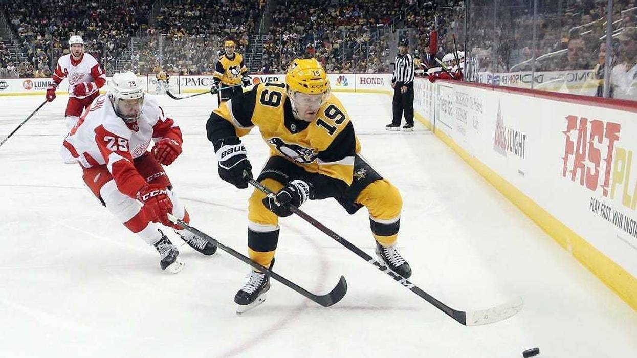 Pittsburgh Penguins center Jared McCann (19) moves the puck ahead of Detroit Red Wings left wing Brendan Perlini (29) during the third period at PPG PAINTS Arena. The Penguins won 5-1.