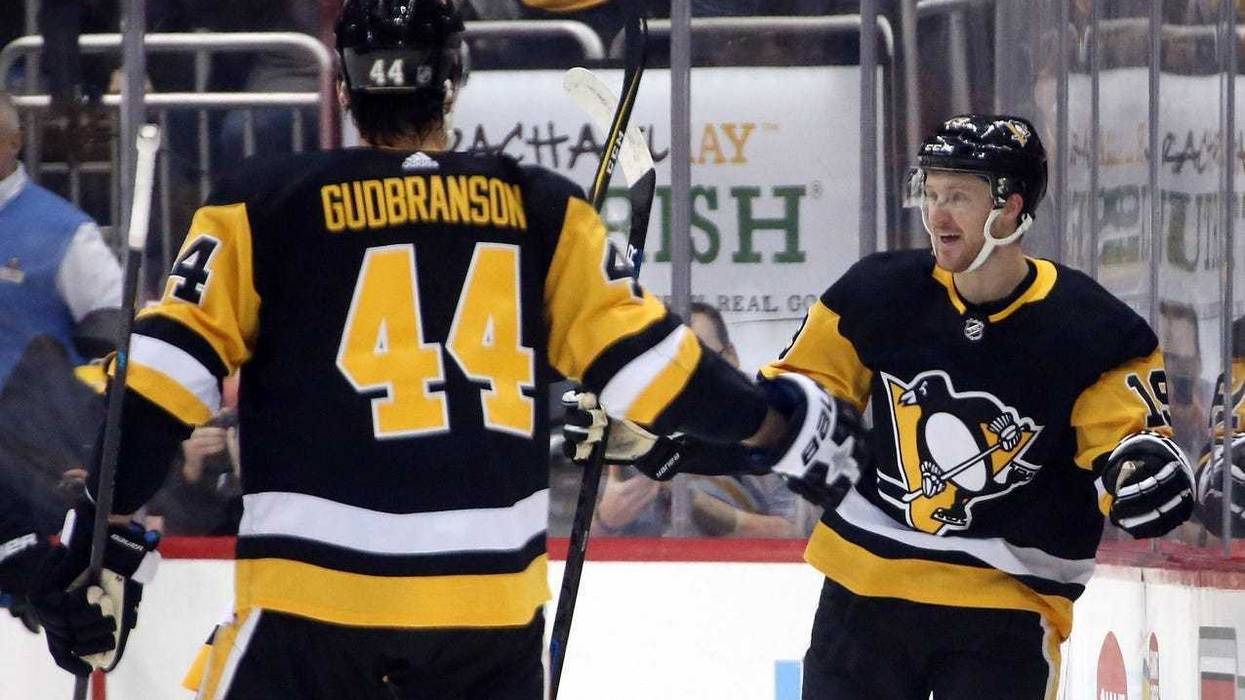 Pittsburgh Penguins center Jared McCann (19) reacts after scoring a goal with Pittsburgh Penguins defenseman Erik Gudbranson (44) against the Boston Bruins during the first period at PPG PAINTS Arena.