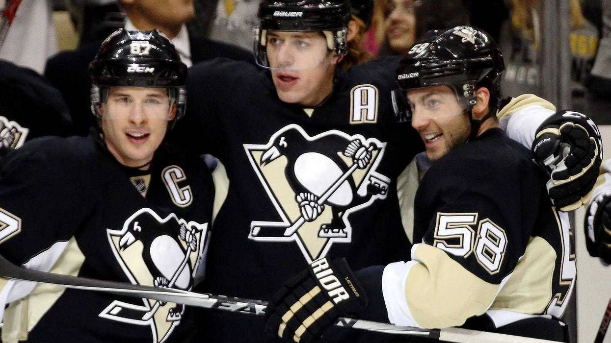 Pittsburgh Penguins center Sidney Crosby (87) and center Evgeni Malkin (71) and defenseman Kris Letang (58) celebrate after a gaol by Malkin against the Vancouver Canucks during the second period at the CONSOL Energy Center.