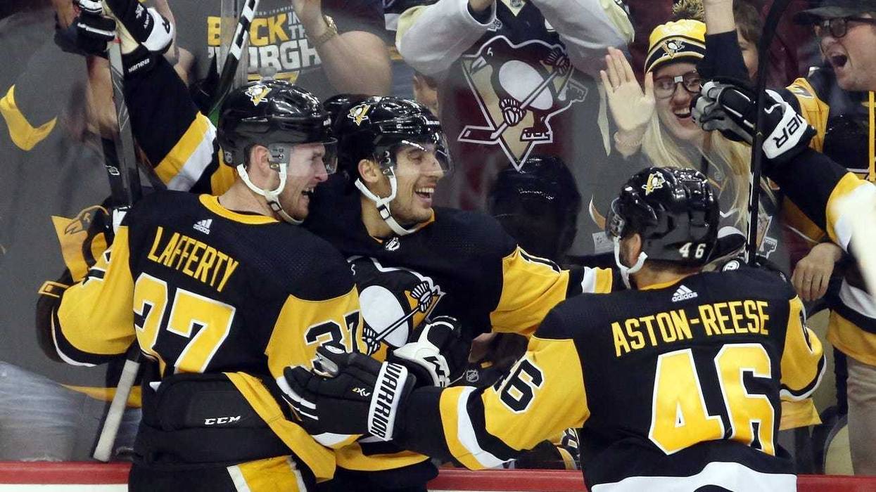 Pittsburgh Penguins left wing Brandon Tanev (middle) celebrates his game winning goal with center Sam Lafferty (37) and center Zach Aston-Reese (46) against the Colorado Avalanche in overtime at PPG PAINTS Arena.