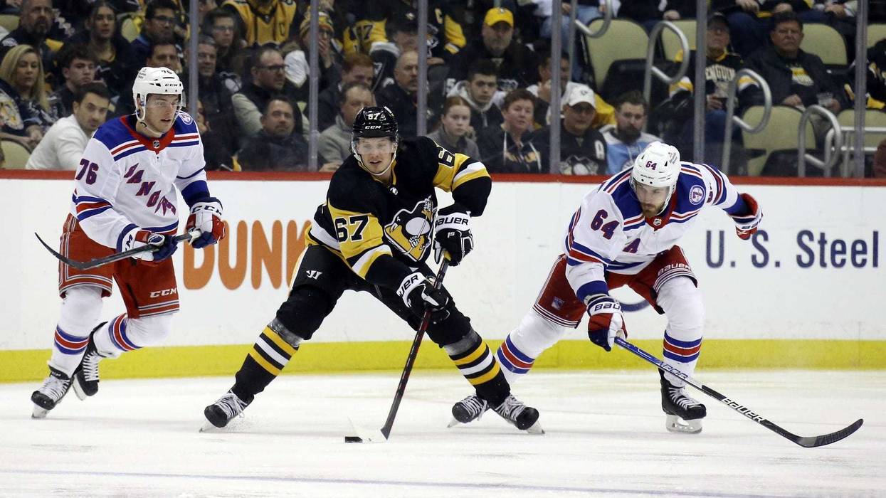 Pittsburgh Penguins right wing Rickard Rakell (67) skates with the puck between New York Rangers center Jonny Brodzinski (76)