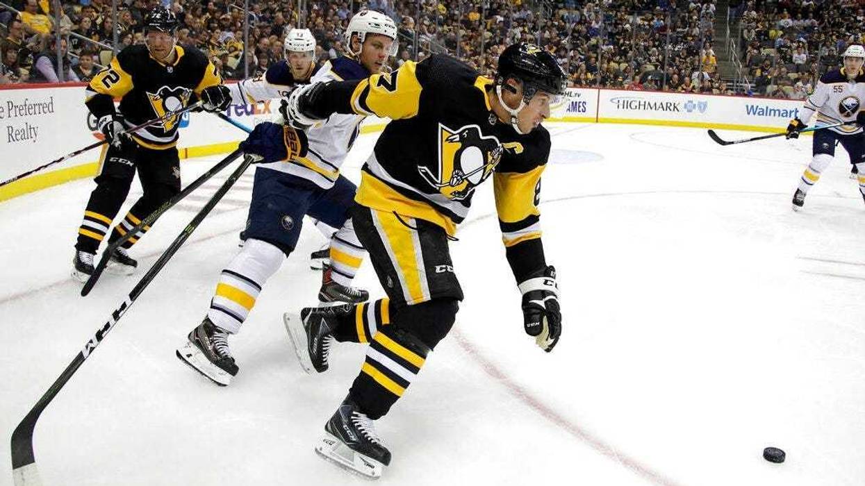 Pittsburgh Penguins' Sidney Crosby (87) can't get his stick untangled from Buffalo Sabres' Vladimir Sobotka during the period of an NHL hockey game in Pittsburgh, Thursday, Oct. 3, 2019.