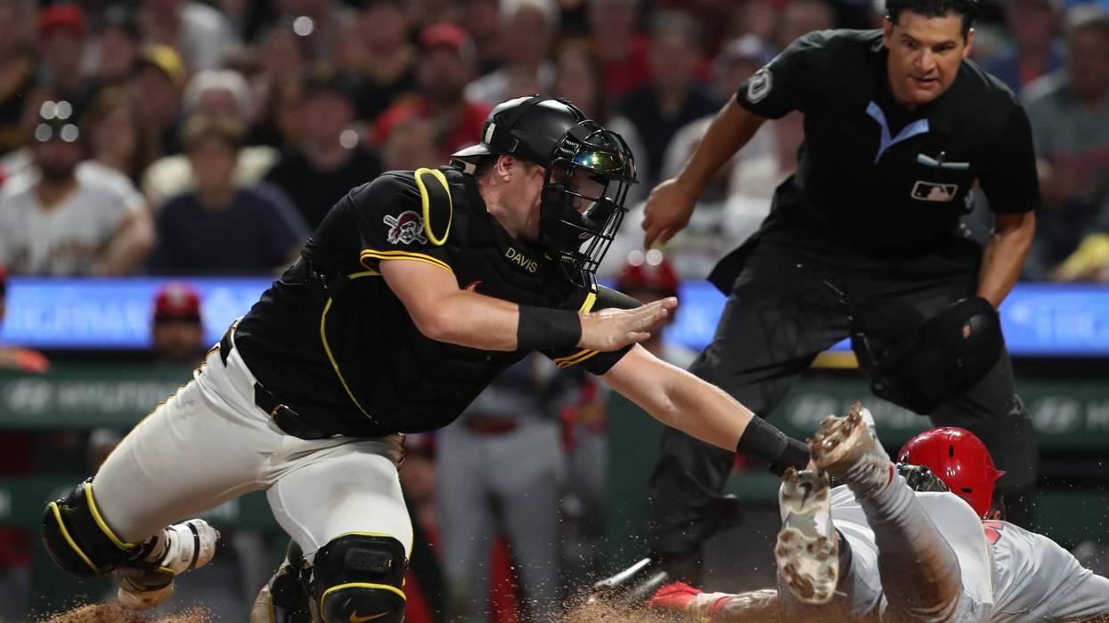 Pittsburgh Pirates catcher Henry Davis (32) tags St. Louis Cardinals designated hitter Jose Fermin (right) out at home plate attempting to score during the ninth inning at PNC Park.