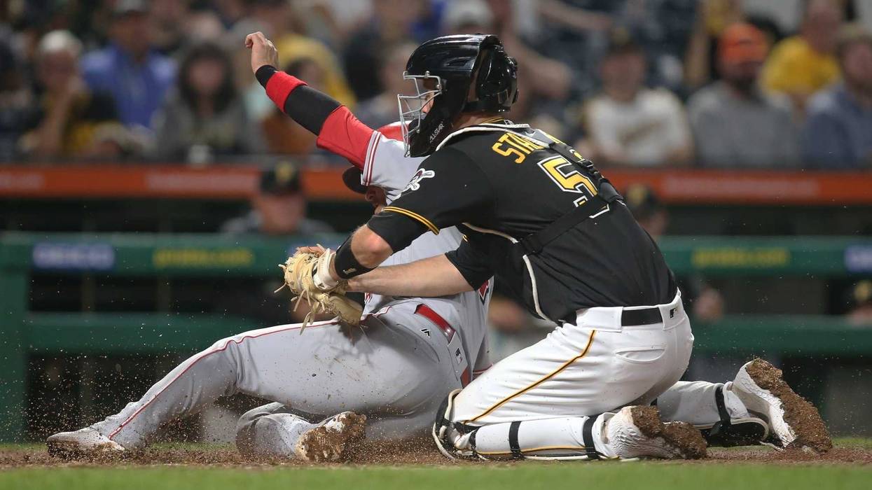 Pittsburgh Pirates catcher Jacob Stallings (58) tags Cincinnati Reds shortstop Jose Iglesias (4) out at home plate