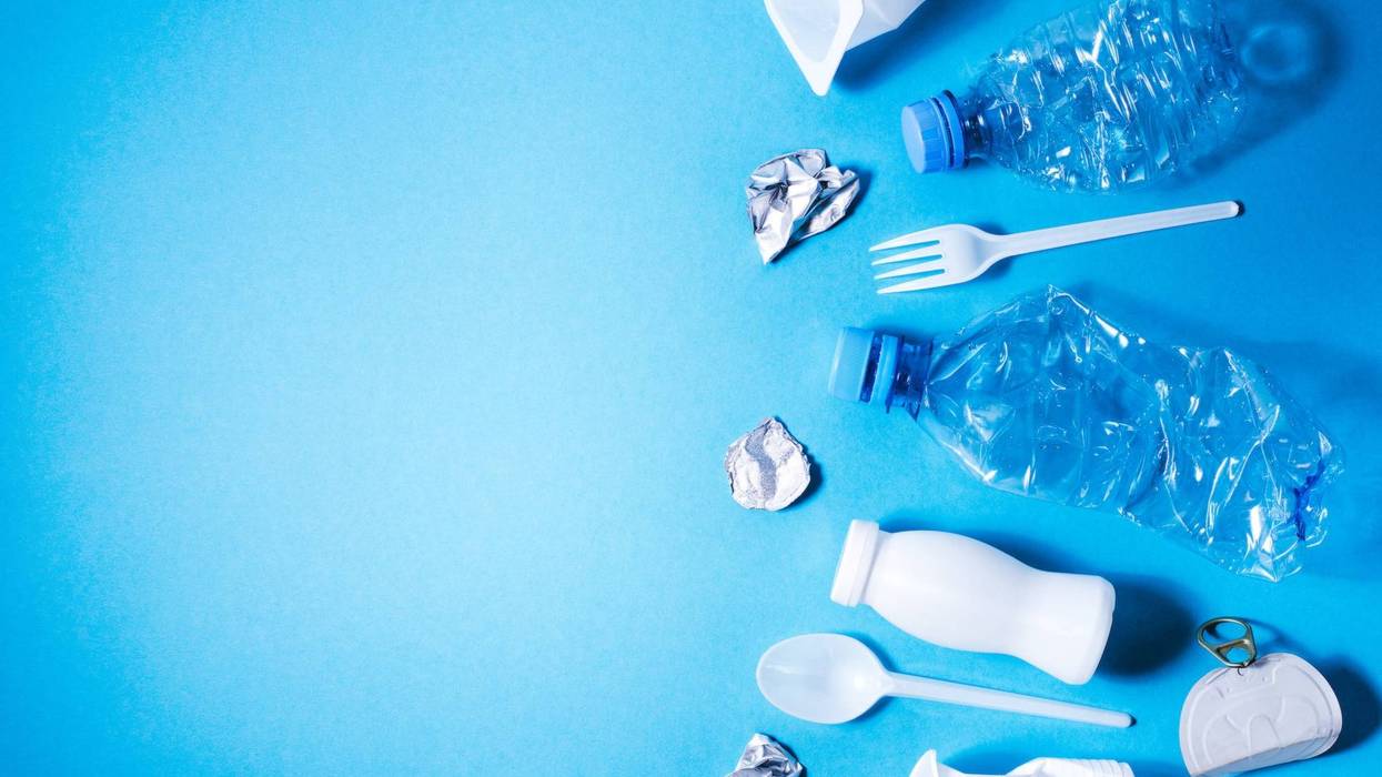 Plastic trash on blue background, eco concept image with copy space.