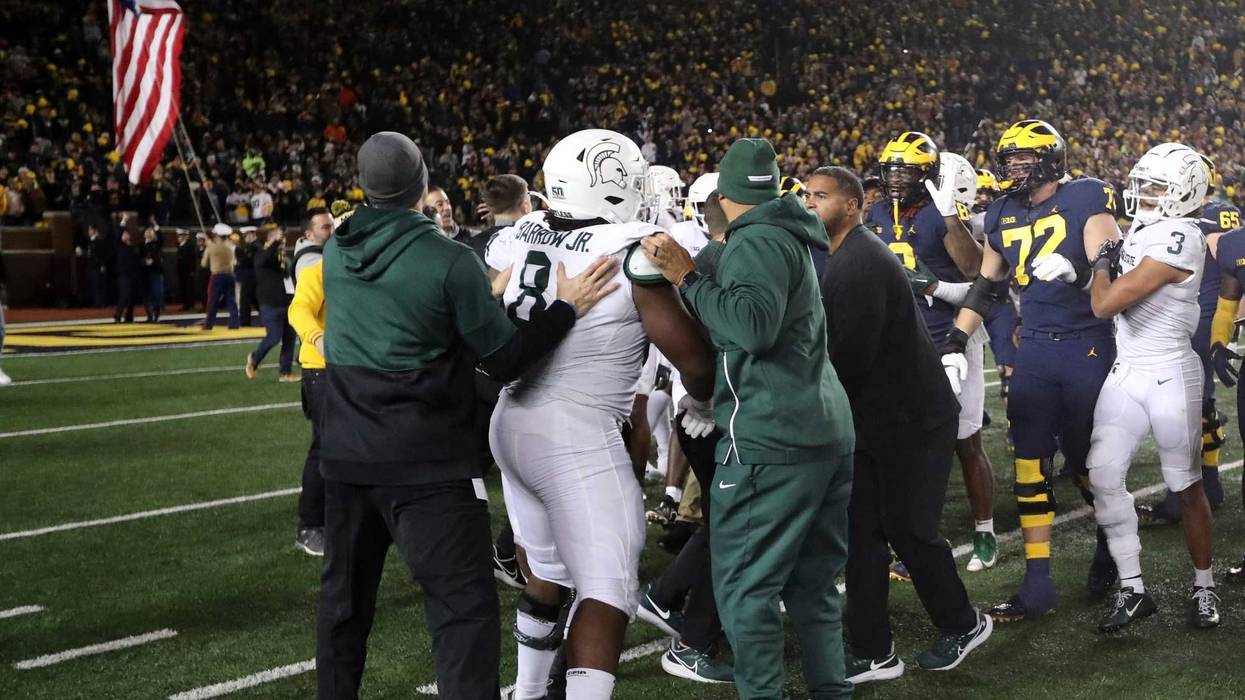 Players scuffling on the field after Michigan-MSU football game