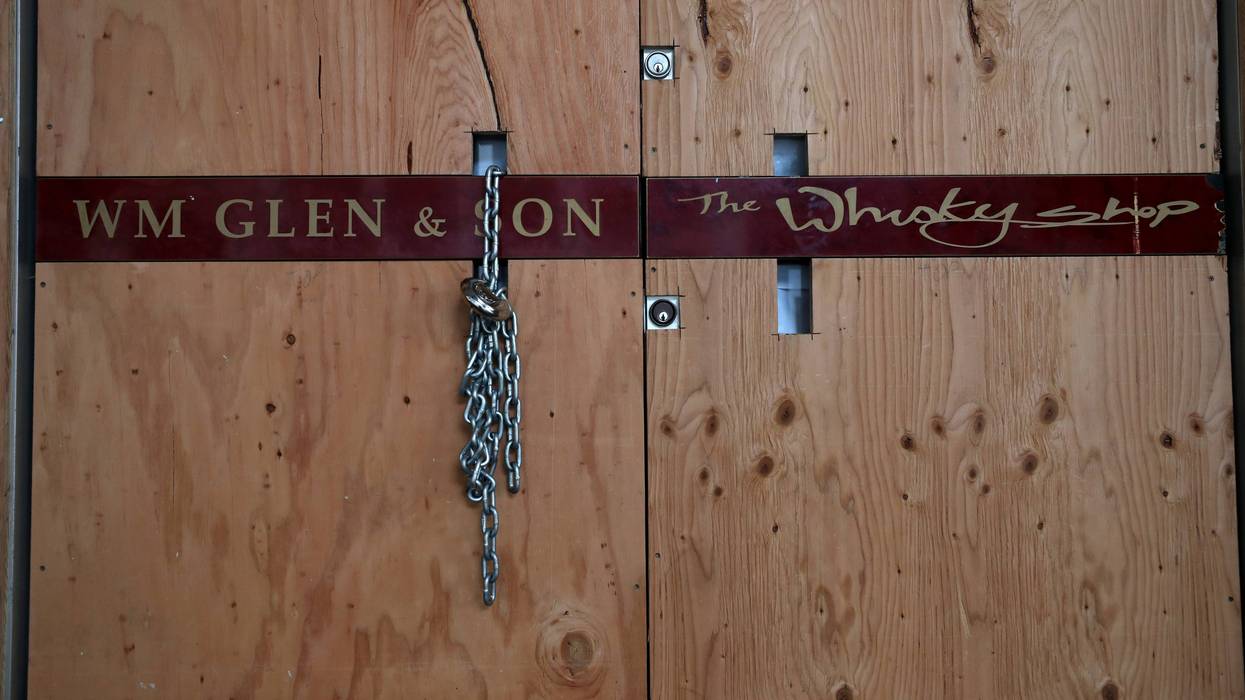 Plywood and a chain lock covers the front door of the Wm Glen & Son store on May 15, 2020 in San Francisco, California.