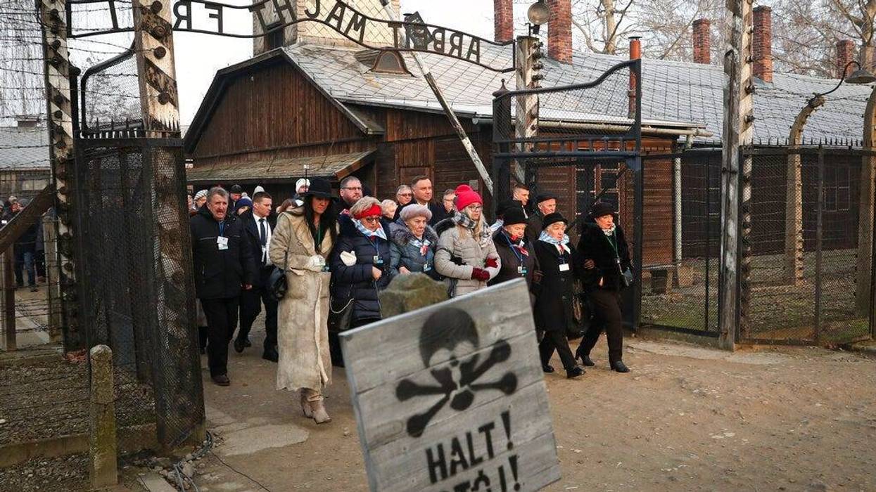Poland's President Andrzej Duda walks along with survivors through the gates of the Auschwitz Nazi concentration camp to attend the 75th anniversary of its liberation in Oswiecim, Poland, Monday, Jan. 27, 2020.
