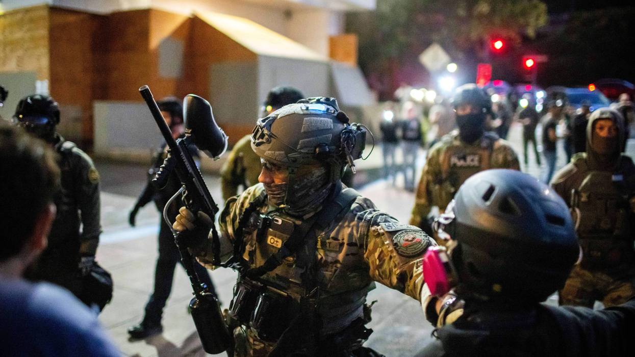 Police and Federal officers stand guard an area by the U.S. Immigration and Customs Enforcement facility in Portland, Ore. on Sunday, Oct. 5, 2025.