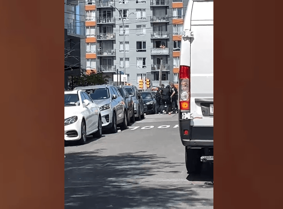 Police appear to take a person into custody near the shooting scene