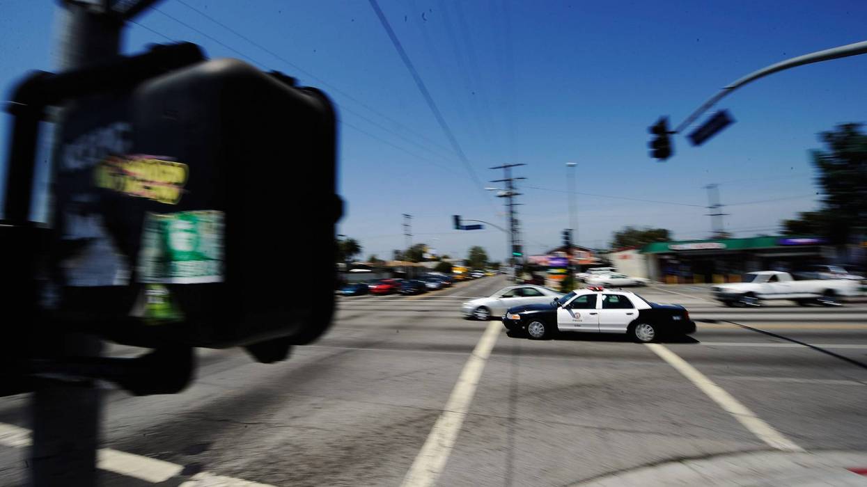 police car speeds through intersection