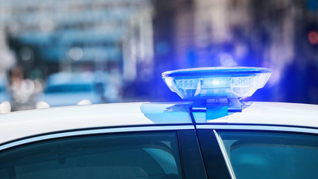 Police car with blue lights in traffic urban environment.