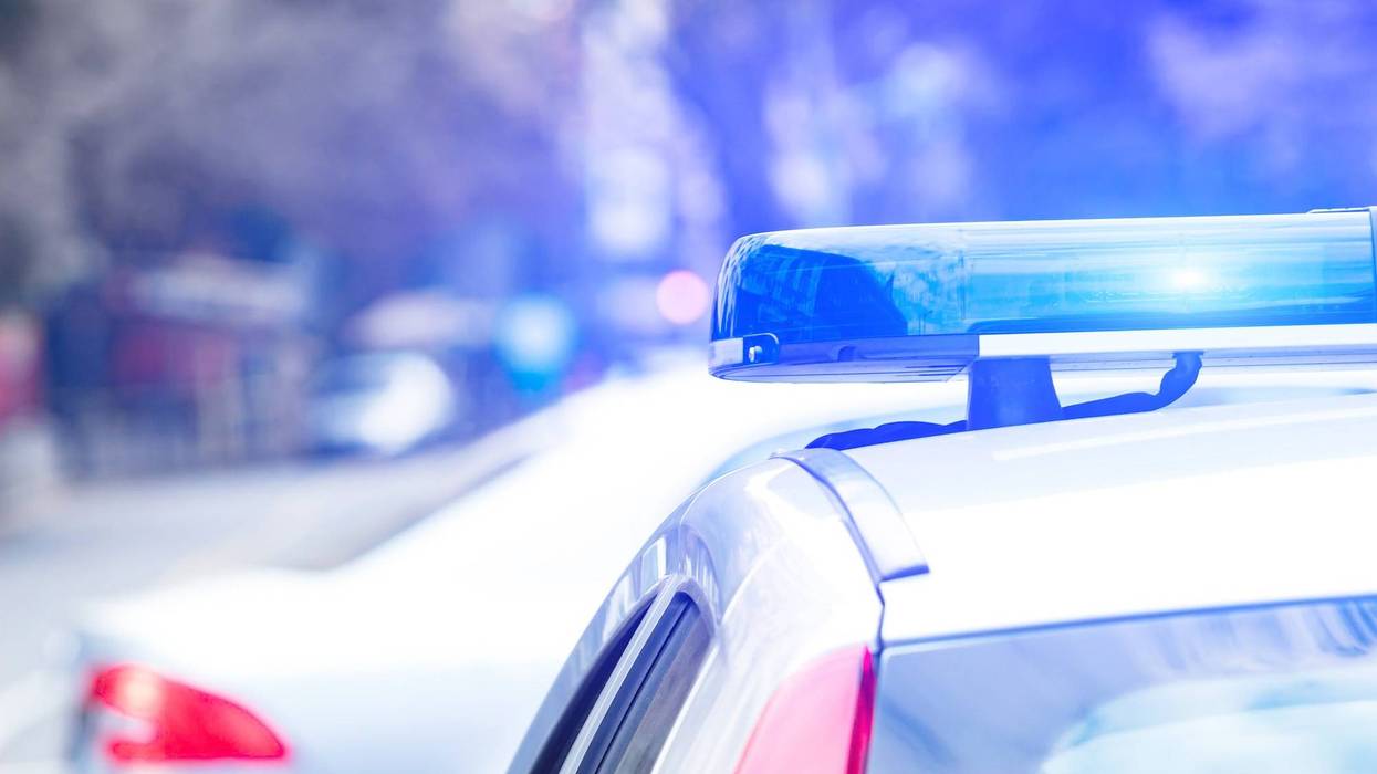 Police car with blue lights on the crime scene in traffic