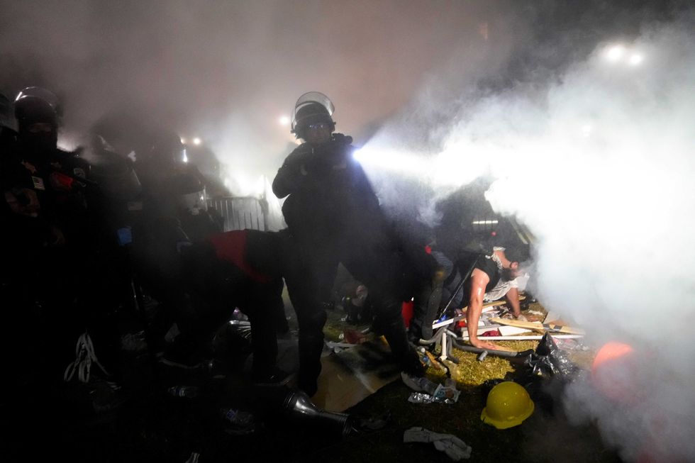 Police enter an encampment set up by pro-Palestinian demonstrators on the UCLA campus Thursday, May 2, 2024, in Los Angeles.