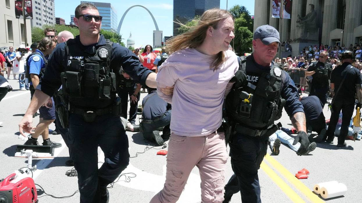 Police escort a protester to a police van after a group supporting Palestine, sat in the middle of Market Street halting the Pride Parade in St. Louis on Sunday, June 30, 2024. Nearly 15 protesters were arrested after chaining themselves to one another inside of a pipe.