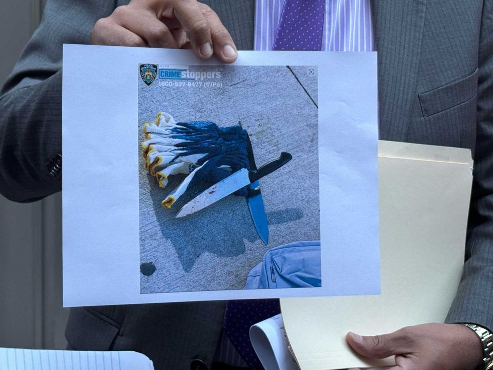 Police hold up a photo of the knives allegedly used in the attacks