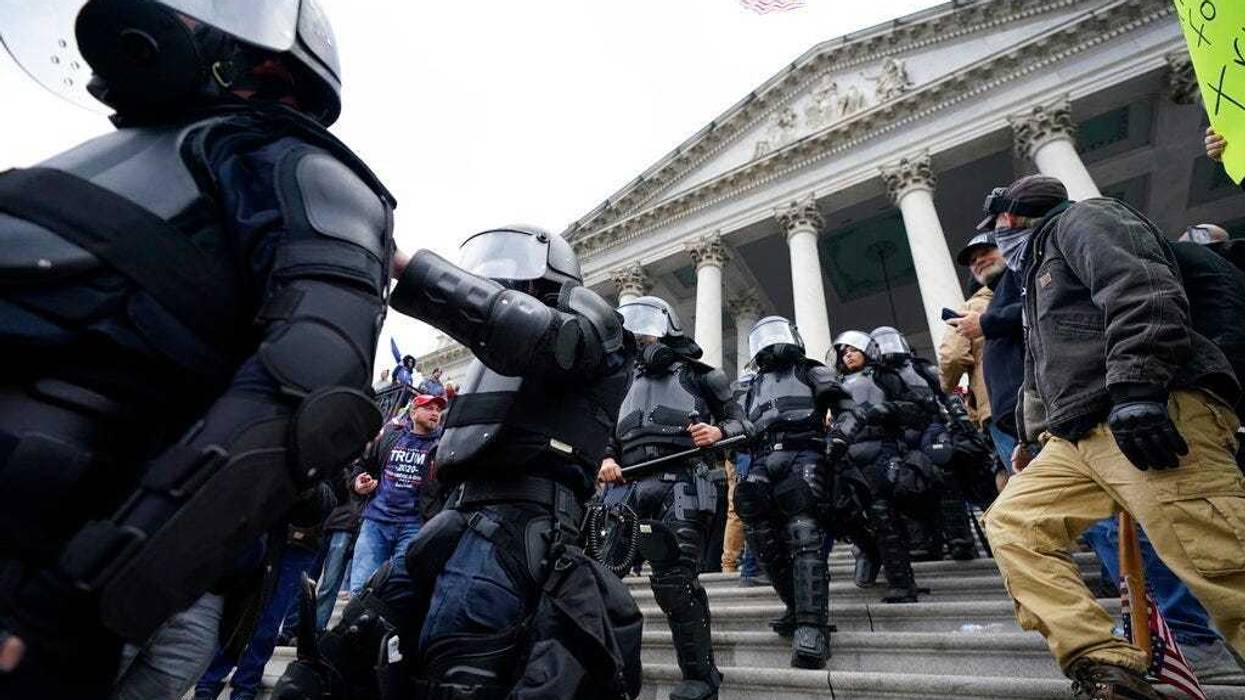 Police in riot gear walk out of the Capitol, Wednesday, Jan. 6, 2021, in Washington.
