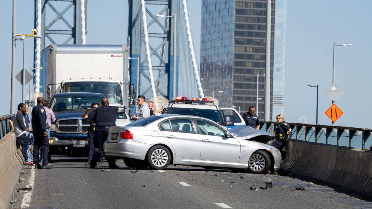 Police investigate near a BMW that crashed on the Manhattan Bridge during a pursuit on April 13, 2023