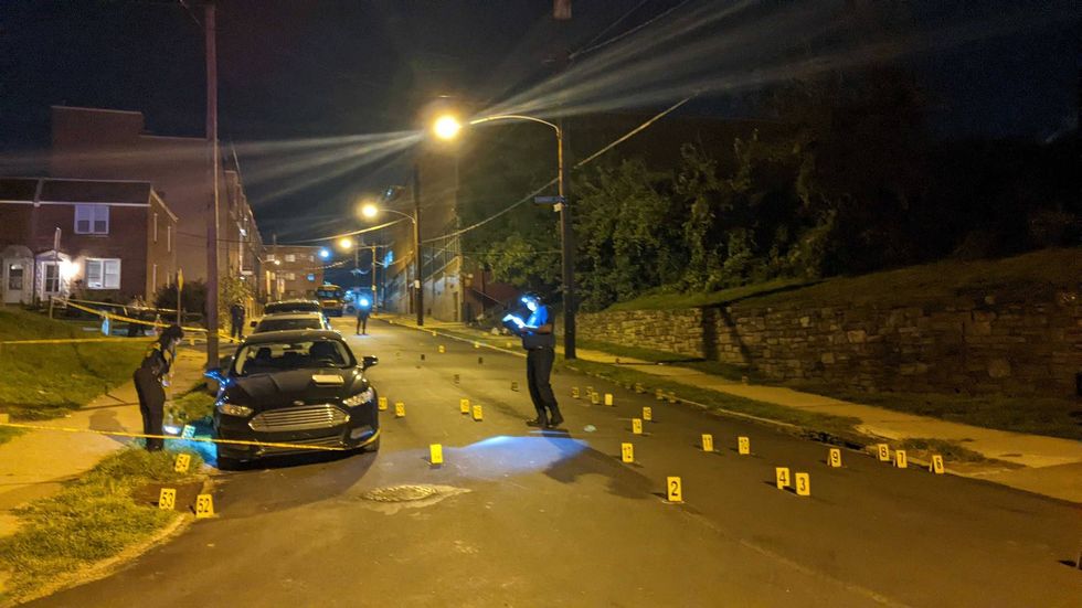 Police investigators document evidence following a drive-by shooting at Roxborough High School on Tuesday.