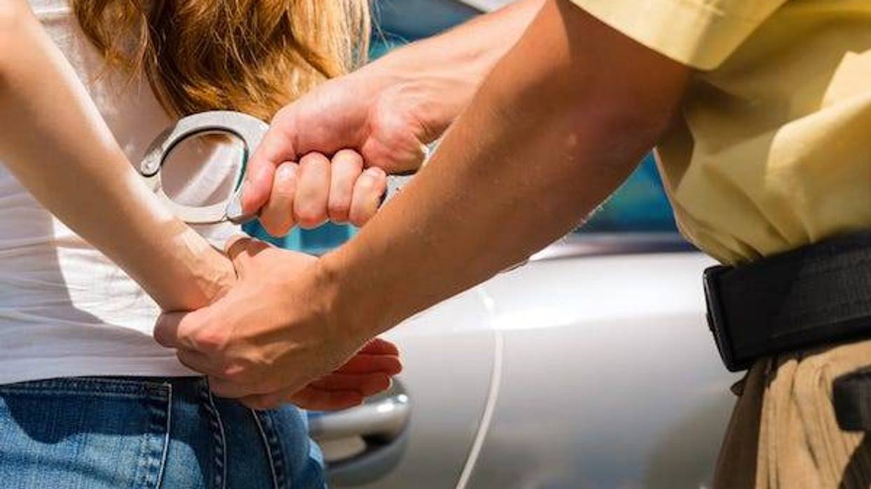 Police officer placing handcuffs on woman