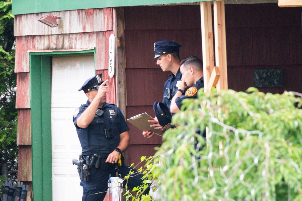 Police officers arrive to the house where a suspect has been taken into custody on New York