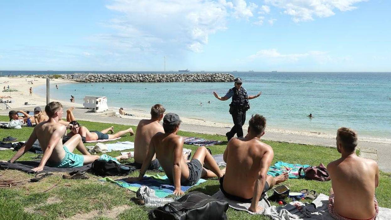 Police officers encourage beach goers to keep 1.5 metres social distance on March 26, 2020 in Perth, Australia.