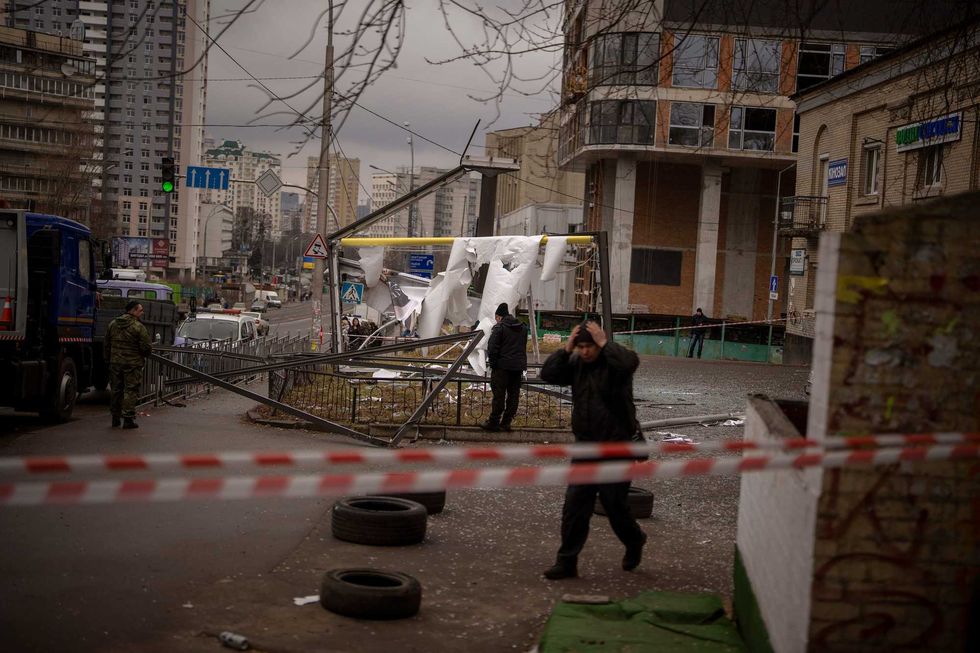 Police officers inspect area after an apparent Russian strike in Kyiv Ukraine, Thursday, Feb. 24, 2022